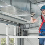 HVAC Professional Worker Checking Last Points of the System From Aluminium Scaffolding. Heating and Cooling Industry Theme.