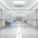 Long hospital bright corridor with rooms and blue seats 3D rendering